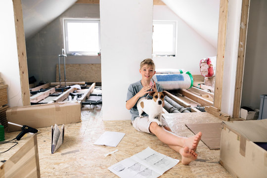 Portrait of smiling boy with dog in a home to be renovated