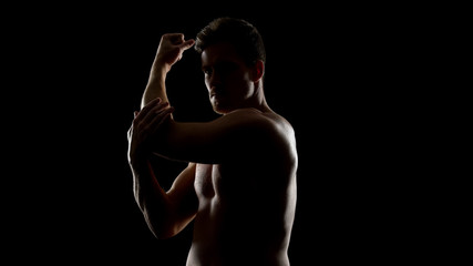Male sportsman doing joint gymnastics before training, warming up, boxing