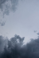 Fototapeta premium Dark thunder clouds on the blue sky. Abstract background with clouds on blue sky.
