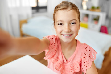 people, children and technology concept - girl taking selfie at home