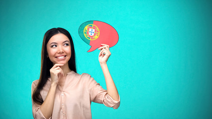 Smiling girl holding Portuguese flag speech bubble learning language travel idea