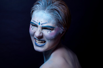 blue makeup for halloween, girl model in the studio with a furious face
