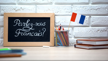 Do you speak French written on board, France flag standing in box, language