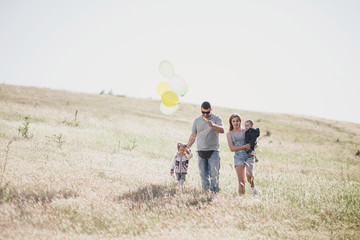 Happy family having fun on sunny meadow.