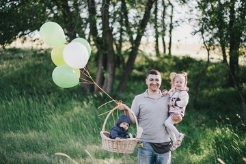 Happy father and his kids having fun in a green park.