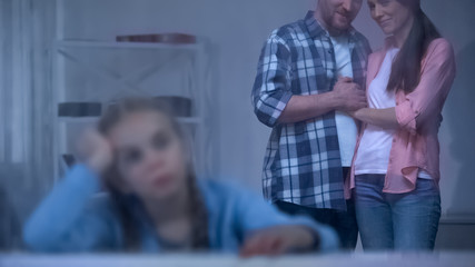 Obraz premium Sad orphan kid near rainy window, foster parents taking girl from orphanage