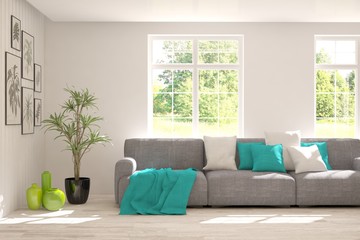 Fototapeta premium Stylish room in white color with sofa and summer landscape in window. Scandinavian interior design. 3D illustration