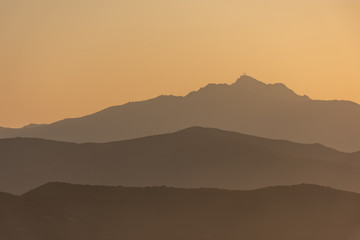 the mountains on the island of Elba at sunset, backlit, turn into a sinuous silhouette