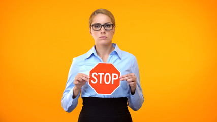 Young business lady holding stop sign hands, sexual harassment at work, protest