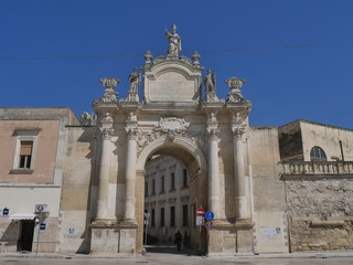 Fototapeta na wymiar Lecce - Rudiae Gate. It is one of the ancient entrance in the city and it was built in baroque style. In its facade take place st Oronzo statue and hight columns supporting the statues of st Oronzo,