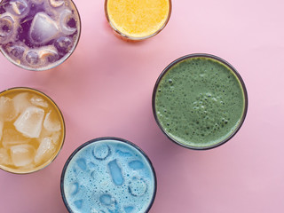 Glasses with colorful summer drinks, cocktails, vegetable strips, coffee drinks and orange juice, top photo, pink background. Concept for restaurant or bar