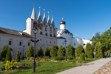 Fototapeta premium The belfry and the Church of the Protection of the Holy Virgin in Tikhvin Assumption (Assumption) monastery. Tikhvin, Russia