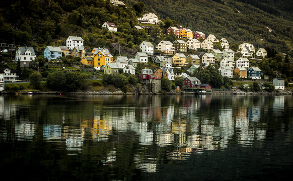 Village houses built on a hillside next to a lake.