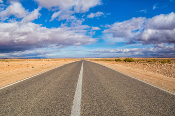 Endless road in the desert of sahara under beautiful clouds in sunny day. Location: Sahara Desert, Morocco, Africa. Artistic picture. Beauty world