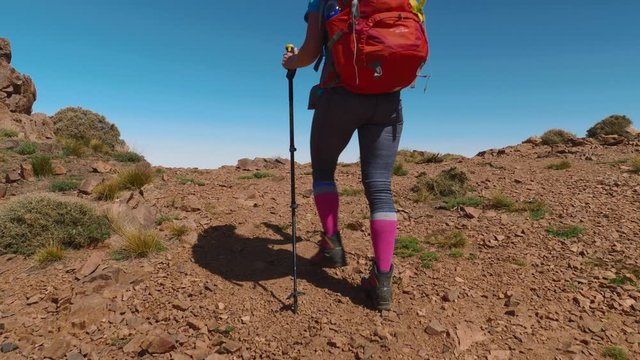 Tourist backpacker girl walking to the mountain ridge in High Atlas, slow motion