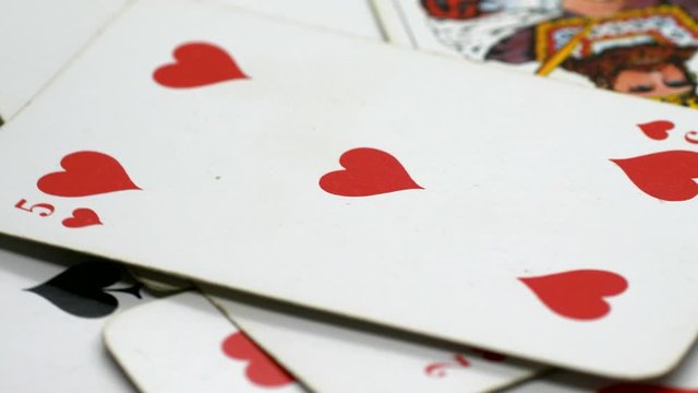 Pack of cards on a moving table, heart five and the king of clubs, in focus