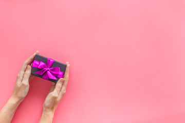 box for gifts in hands on pink background top view mock up
