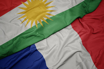 waving colorful flag of france and national flag of kurdistan.
