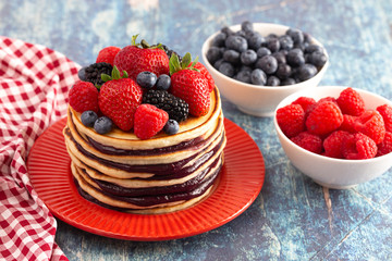 Berry Pancakes with Compote Spread on a Rustic Blue Wood Table