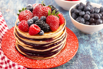 Berry Pancakes with Compote Spread on a Distressed Blue Wood Table