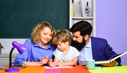 Happy family. School community partnership models. Child from elementary school with parents in school. Elementary student. Little boy and his parents in classroom. Kids at preschool. Back to school.