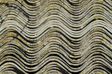 Corrugated slate lies in a pile, side view background texture of slate.