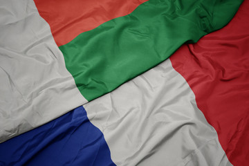 waving colorful flag of france and national flag of madagascar.