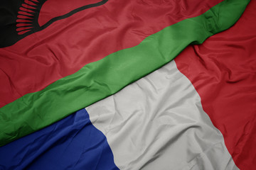 waving colorful flag of france and national flag of malawi.