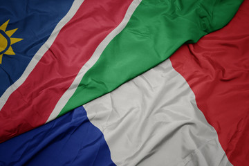 waving colorful flag of france and national flag of namibia.