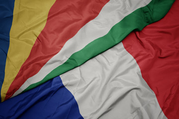 waving colorful flag of france and national flag of seychelles.