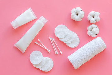 Hygiene cotton swabs, pads and cream for pattern on pink background top view