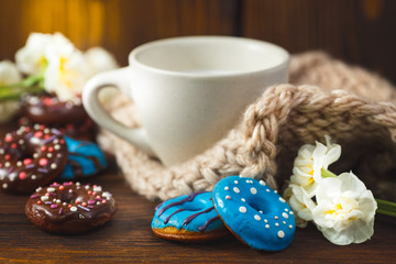 Cakes donuts with a cup of milk over wooden background. Table with morning breakfast dessert and milk. Trendy donut with chocolate and blue glaze.