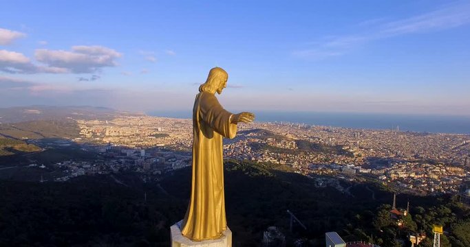 Aerial view of Statue of Jesus on the top of Sagrat Cor church with Barcelona on background, Spain