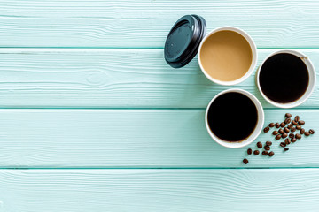 paper cups with black coffee and cappuccino to take away, beans on mint green wooden background top view mockup