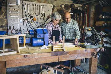 Senior couple working in a carpentry workshop