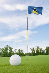 Obraz premium Saint Lucia flag on golf course putting green with a ball near the hole