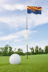 Obraz premium Arizona flag on golf course putting green with a ball near the hole