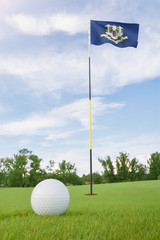 Obraz premium Connecticut flag on golf course putting green with a ball near the hole