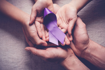 Adult and child hands holding purple ribbons, Alzheimer's disease, Pancreatic cancer, Epilepsy awareness, world cancer day, domestic violence concept