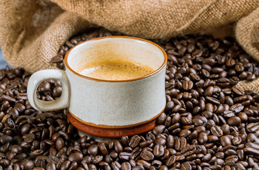 Coffee cup and beans on a wooden table.