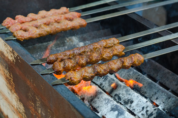 Cooking adana kebabs on a grill in restaurant 