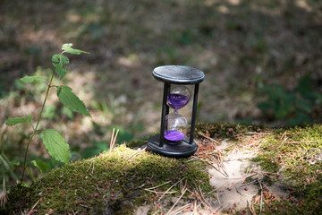 Sand running through the bulbs of an hourglass measuring the passing time in a countdown to a...