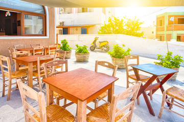 Beautiful Sunny Summer Restaurant on Santorini Island in Greece with Scooter on Background.