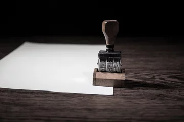 Foto op Canvas Close up view of rubber date stamper on wooden table with dark toned foggy background. © zef art