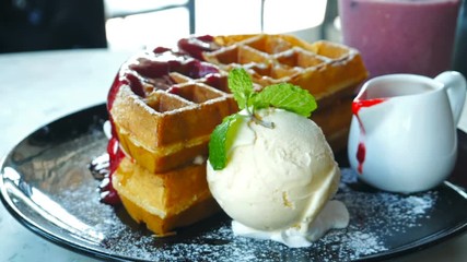 human hand poring strawberry sauce to the waffles and Ice cream, dessert