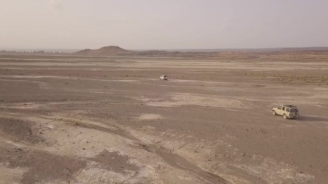 2018 - beautiful aerial over two 4x4 jeeps traveling across the deserts of Djibouti or Somalia.