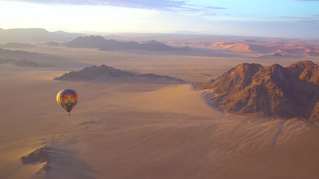 Hot air balloons fly in the Namib desert in Namibia.