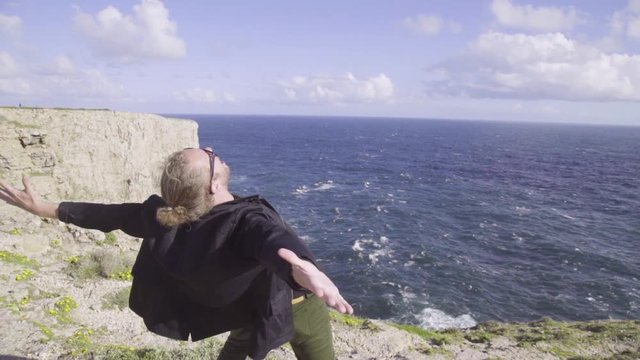 A man yells I'm At The End Of The World into the void of the Atlantic Ocean, Portugal.