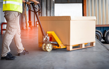 Workers Courier Using Hand Pallet Jack Unloading Package Boxes Pallet into Cargo Container....