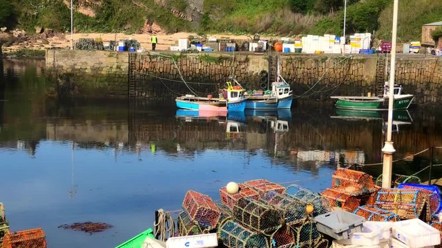 Fishing boat tying up in Crail Harbour Fife Scotland with lobster creels in the foreground.